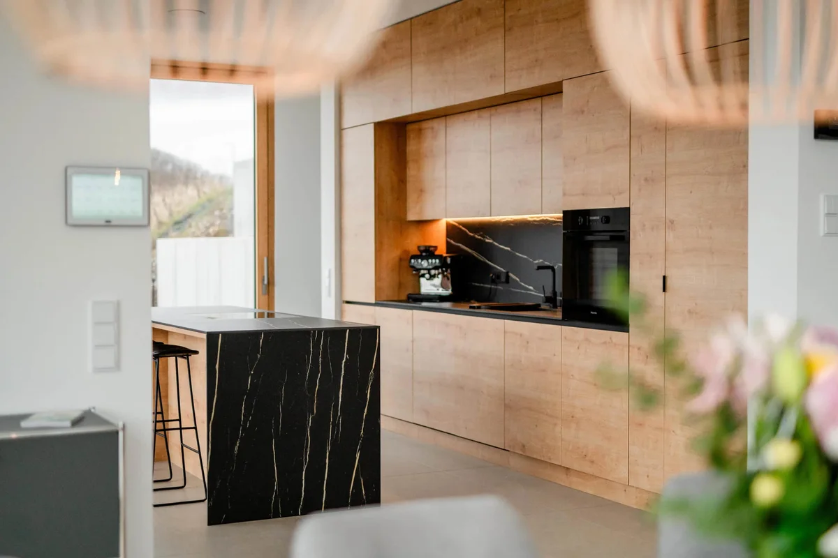 Küche mit Holzfronten und dunkler Kochinsel im Ferienhaus Moselpanorama in Leiwen